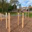 Outdoor fitness station Bars I with wooden and metal elements in a park.