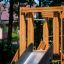Wooden playground equipment with a slide in the forest, part of the Logo Tower Nature single slide.