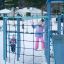 Butterfly blue climbing frame with rope net on snowy playground.