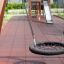 Bird Nest (âŚ€ 90 cm) Wooden Swing hanging on playground with slide in background