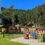 Alpha playhouse with slide on a sunny playground near the forest
