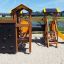 Outdoor Alpha playhouse with slide in a playground.