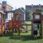 Alpha playhouse with slide in playground with children playing