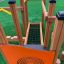 Playground structure Trixie with wooden frame and rope bridge on artificial grass.