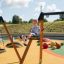 a boy swinging on the wooden swing