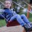 a girl swinging on the playground swing