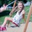 a girl swinging on the wooden swing