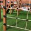 Playground climbing structure Romping Corner Nature with rope net fencing.