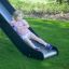 Child sliding down metal slide on Romping Corner Nature playground.