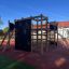 Climbing Booth Nature, wooden playhouse with climbing walls and slide in a playground.
