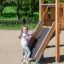 Child playing on Hexagon Modern Nature single slide at a playground.