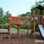 Triangle Modern Nature wooden playhouse with slide in a park decorated with colorful balloons