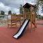 Triangle Modern Nature wooden playhouse with slide on playground