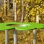 Clover Play Table in a park setting with green top and metal legs.