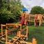 Queen Jubilee playhouse with slide in a garden setting.