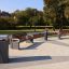 Modern outdoor benches and Chicago bin in a park setting.