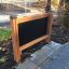 Outdoor 'Blackboard' with wooden frame placed in a park.