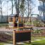 Blackboard in modern playground with playhouse and swings in the background.