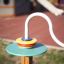 Colorful playground equipment Rings by LarsLaj is installed on a wooden post.