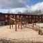 Sonora wooden playhouse in a sandy playground area
