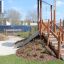 Playground structure Hekla with wooden steps and slide in a park