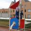 Child playing on Neptune single playhouse with red roof and yellow platform.