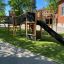 Children's outdoor play structure Challenger Nature II in a school playground with a slide and bridg