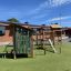 Playground equipment Rope Center in a schoolyard with climbing structures and playhouses.