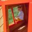 Child playing inside Anna's Playhouse wooden structure.