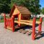 Wooden playhouse with red accents on a playground.