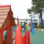 wooden play house with red fencing