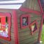 a boy looking through the garden playhouse window