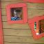 a boy inside an outdoor playhouse