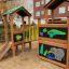 Jungle House playhouse with slide in a playground.