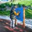 Child playing with the Bingo Board outdoor activity panel in a park.