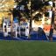 Playground structure Winter Mansion with slides and climbing walls among trees.