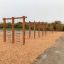 Wooden outdoor play structure with climbing ladders.