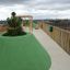 Green hill-shaped Wetpour 45 playground surface with trees on a rooftop.