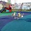 Playground covered with Wetpour 45 rubber surfacing, featuring slides and spring rockers