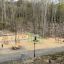 Outdoor Trim Trail with various wooden exercise stations in a forest setting.
