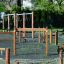 Trim trail wooden playground fitness equipment with swings and climbing nets in a park