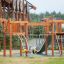 Khumbu wooden playground equipment with slide and climbing ropes on safety surface.