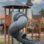 Khumbu playground grey spiral slide with wooden climbing structure under a small roof.