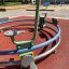 Bicycle merry-go-round on playground with red rubber surface