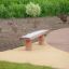 Robinia bench made of natural wood on playground surface.