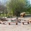 Robinia bench around a fire pit in a park setting