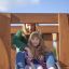Mother and daughter sliding down the Kanha wooden playhouse slide