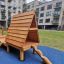 Kanha wooden playhouse with slide in a modern apartment courtyard