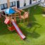 Outdoor playground with a red slide and climbing structure for children.