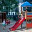 Bird Nest Swing with Tower (BNS 120 cm) single slide in use at playground with children playing.